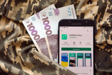 TERNOPIL, UKRAINE - 24 Nisan 2022: Akıllı telefon ekranında UkrSib bankacılık uygulaması. UkrSib Ukrayna 'da önemli bir ticari bankadır.