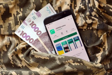 TERNOPIL, UKRAINE - 24 Nisan 2022: Akıllı telefon ekranında UkrSib bankacılık uygulaması. UkrSib Ukrayna 'da önemli bir ticari bankadır.