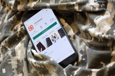 TERNOPIL, UKRAINE - 24 Nisan 2022: Zello Walkie mobil uygulama logosu, Ukrayna askeri kamuflaj üniformasına yakın çekim ekranında Play Market 'ten