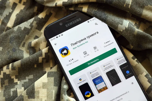 TERNOPIL, UKRAINE - 24 Nisan 2022: Askeri kamuflaj üniformasında akıllı telefon ekranında cep telefonu için Hava Baskını Siren uygulaması