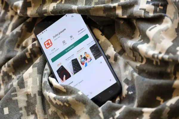 TERNOPIL, UKRAINE - 24 Nisan 2022: Zello Walkie mobil uygulama logosu, Ukrayna askeri kamuflaj üniformasına yakın çekim ekranında Play Market 'ten