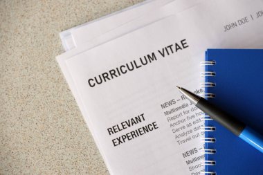 Kalem ve not defterine yakın masadaki özgeçmiş ve CV formları da dahil olmak üzere ofis belgelerinin üst görüntüsü. İş arama süreci. İş yeri konsepti için avlanma