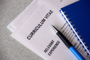 Kalem ve not defterine yakın masadaki özgeçmiş ve CV formları da dahil olmak üzere ofis belgelerinin üst görüntüsü. İş arama süreci. İş yeri konsepti için avlanma