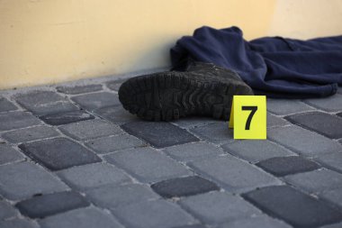 Akşamları arka bahçede numaralandırılan sarı CSI işaretli kanıt. Olay yeri inceleme süreci kavramı