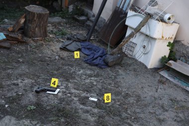 Akşamları arka bahçede numaralandırılan sarı CSI işaretli kanıt. Olay yeri inceleme süreci kavramı