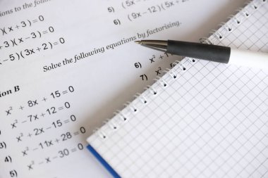 Handwriting of mathematics quadratic equation on examination, practice, quiz or test in maths class. Solving exponential equations background concept.