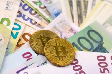 Avro ve dolar banknotlu Bitcoin kapanıyor. Masada çok para ve bozuk para var. İş ve kripto para birimi kavramı. Popüler ve önemli para birimi