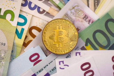 Avro ve dolar banknotlu Bitcoin kapanıyor. Masada çok para ve bozuk para var. İş ve kripto para birimi kavramı. Popüler ve önemli para birimi