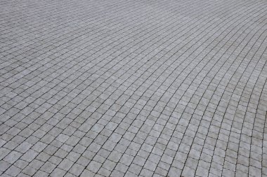 Yaya kaldırımındaki gri asfalt levhalar. Sert kaldırım taşı desenli, kare şeklinde birçok taş var.