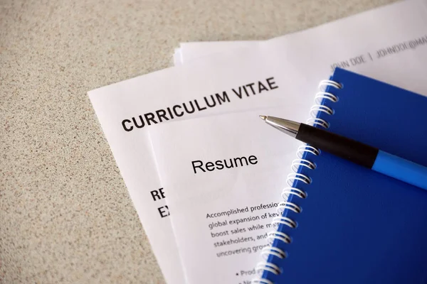 Kalem ve not defterine yakın masadaki özgeçmiş ve CV formları da dahil olmak üzere ofis belgelerinin üst görüntüsü. İş arama süreci. İş yeri konsepti için avlanma