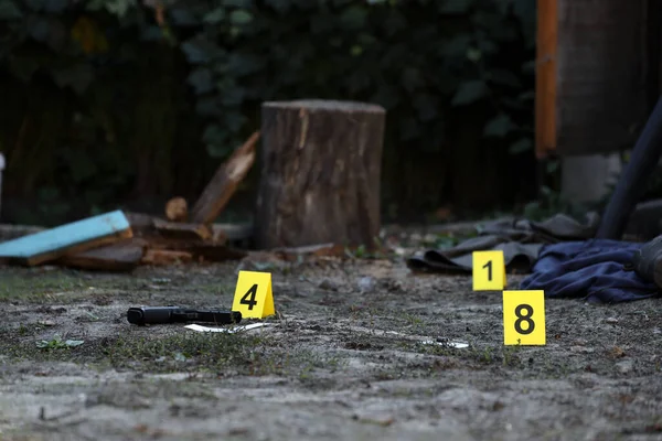 Evidence with yellow CSI marker for evidence numbering on the residental backyard in evening. Crime scene investigation process concept