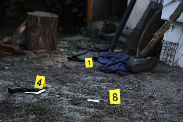 Akşamları arka bahçede numaralandırılan sarı CSI işaretli kanıt. Olay yeri inceleme süreci kavramı