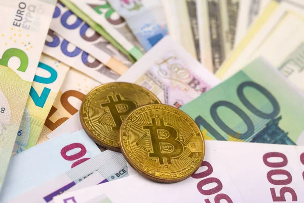 Avro ve dolar banknotlu Bitcoin kapanıyor. Masada çok para ve bozuk para var. İş ve kripto para birimi kavramı. Popüler ve önemli para birimi