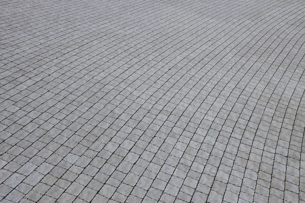 Yaya kaldırımındaki gri asfalt levhalar. Sert kaldırım taşı desenli, kare şeklinde birçok taş var.