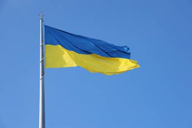 Mavi gökyüzünde kırpma yolu ile izole edilmiş Ukrayna bayrağı. Ukrayna 'nın el sallayan sancağını kapat. Avrupa özgürlük ülkesi Ukrayna 'nın uzun bayrak sembolü