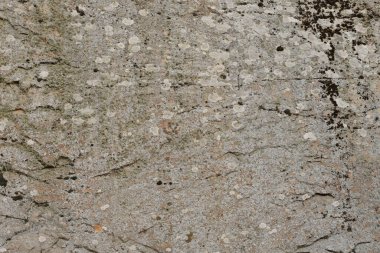 Doğal arka plan kavramları için büyük bir kaya yüzeyinin kaba taş dokusuna yakın çekim. Kirli doğal taştan arkaplan dokusu sıcak tonlarda