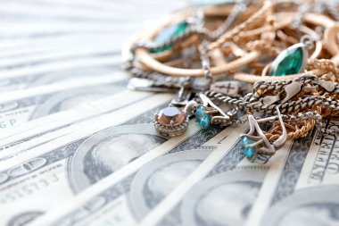 Birçok pahalı altın ve gümüş mücevher yüzük, küpe ve kolye büyük miktarlarda Amerikan dolarına yakın. Rehinci ya da kuyumcu konsepti.