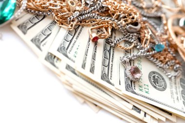 Birçok pahalı altın ve gümüş mücevher yüzük, küpe ve kolye beyaz arka planda büyük miktarda Amerikan doları var. Rehinci ya da kuyumcu konsepti.
