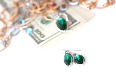 Birçok pahalı altın ve gümüş mücevher yüzük, küpe ve kolye beyaz arka planda büyük miktarda Amerikan doları var. Rehinci ya da kuyumcu konsepti.