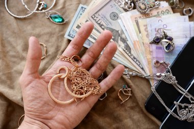 Çalıntı mücevher, para ve akıllı telefonları askeri üniforma kumaşına takmış yağmacılar. Rus askerlerinin Ukrayna işgali sırasında Ukrayna şehirlerinde yağmalaması.