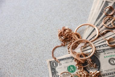 Bir sürü pahalı altın mücevher yüzük, küpe ve içinde fotokopi alanı olan Amerikan dolarları olan kolyeler. Rehinci ya da kuyumcu konsepti.