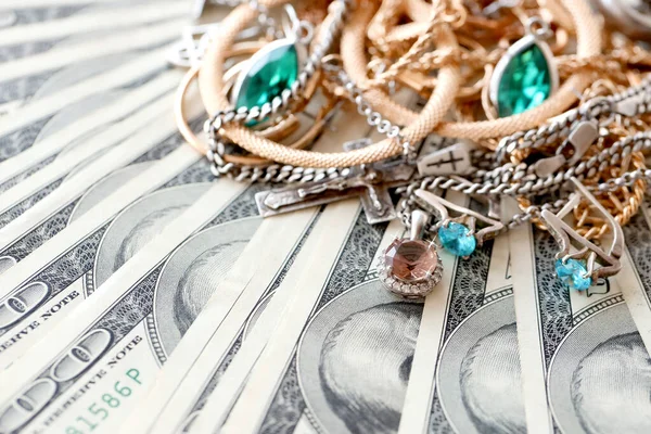 Birçok pahalı altın ve gümüş mücevher yüzük, küpe ve kolye büyük miktarlarda Amerikan dolarına yakın. Rehinci ya da kuyumcu konsepti.