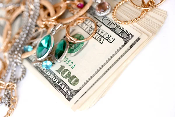 Birçok pahalı altın ve gümüş mücevher yüzük, küpe ve kolye beyaz arka planda büyük miktarda Amerikan doları var. Rehinci ya da kuyumcu konsepti.
