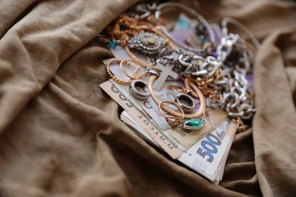 Bir sürü çalıntı mücevher ve askeri üniforma kumaşına para. Rusya 'nın Ukrayna' ya saldırısı sırasında Rus askerleri tarafından Ukrayna şehirlerinde yağmalanmış. Yağmacılar ve yağmacılar konsepti