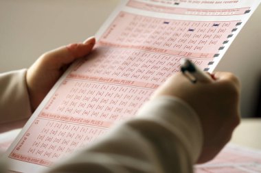 Piyango bileti dolduruyorum. Genç bir kadın piyango oynar ve büyük ikramiyeyi kazanmayı hayal eder. Kumar konsepti