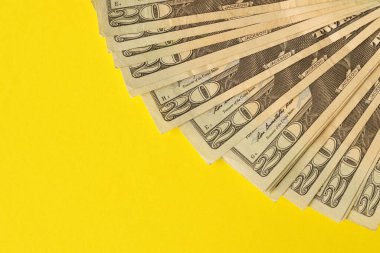 Big amount of old twenty dollar bills on yellow background. Money earnings, payday or tax paying period concept