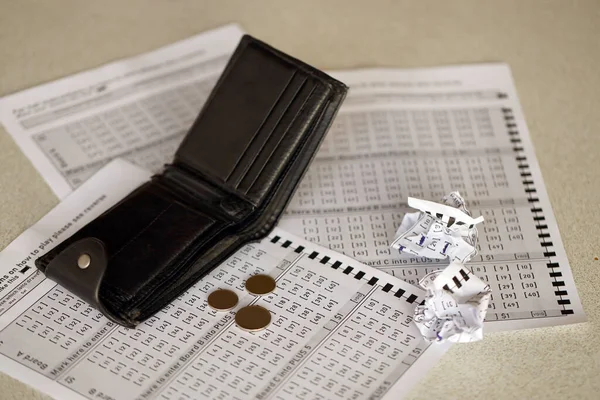 Crumpled lottery tickets and empty purse as symbol of losing the lottery game. Unlucky gambling results. Misfortune and money spending