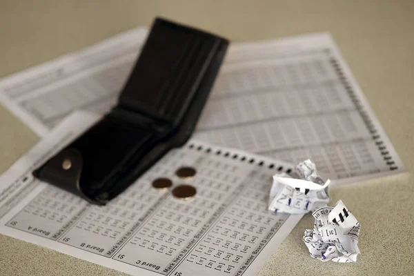 Crumpled lottery tickets and empty purse as symbol of losing the lottery game. Unlucky gambling results. Misfortune and money spending