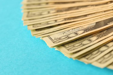 Mavi arka planda büyük miktarda eski 20 dolarlık banknotlar. Para kazanma, ödeme günü veya vergi ödeme dönemi kavramı
