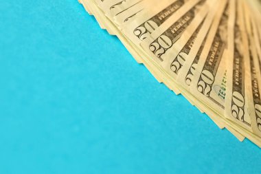 Mavi arka planda büyük miktarda eski 20 dolarlık banknotlar. Para kazanma, ödeme günü veya vergi ödeme dönemi kavramı