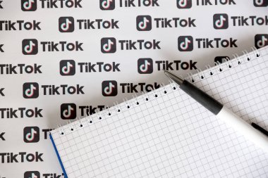 TERNOPIL, UKRAINE - 2 Mayıs 2022: Kalemle ve kağıda basılmış birçok TikTok logosuyla Not. Tiktok veya Douyin, ByteDance Ltd. 'nin sahibi olduğu Çin yapımı kısa formatlı video sunucu servisidir.