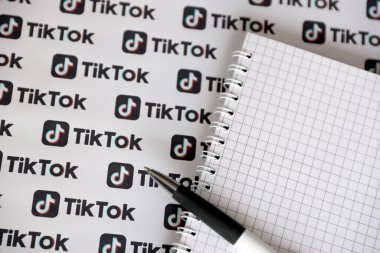 TERNOPIL, UKRAINE - 2 Mayıs 2022: Kalemle ve kağıda basılmış birçok TikTok logosuyla Not. Tiktok veya Douyin, ByteDance Ltd. 'nin sahibi olduğu Çin yapımı kısa formatlı video sunucu servisidir.