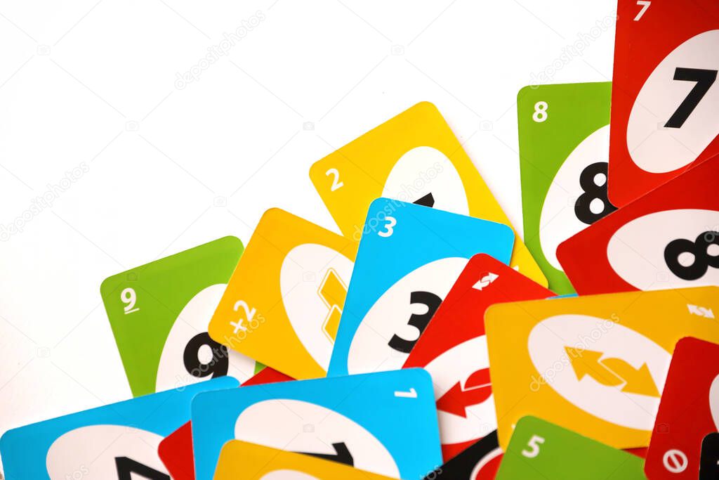 TERNOPIL, UKRAINE - MAY 15, 2022: Many colorful UNO game cards on white background close up. UNO is an American shedding-type card game that is played with a specially printed deck
