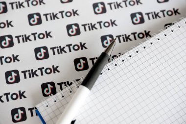 TERNOPIL, UKRAINE - 2 Mayıs 2022: Kalemle ve kağıda basılmış birçok TikTok logosuyla Not. Tiktok veya Douyin, ByteDance Ltd. 'nin sahibi olduğu Çin yapımı kısa formatlı video sunucu servisidir.