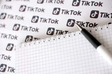TERNOPIL, UKRAINE - 2 Mayıs 2022: Kalemle ve kağıda basılmış birçok TikTok logosuyla Not. Tiktok veya Douyin, ByteDance Ltd. 'nin sahibi olduğu Çin yapımı kısa formatlı video sunucu servisidir.