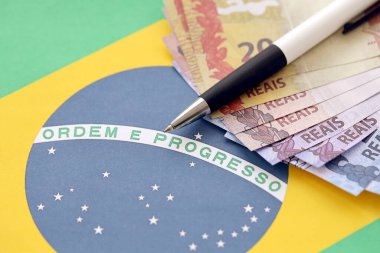 Brezilya cumhuriyetinin bayrağında Brezilya parası olan bir kalem. Brezilya 'da iş, muhasebe veya vergi ödeme kavramı
