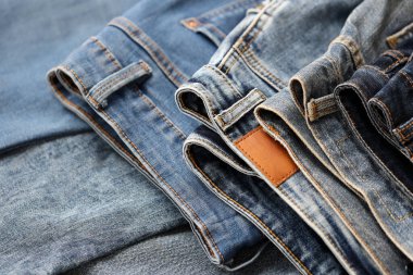 Soyunma odasında bir sürü kot pantolon var. Dolapta pantolon pantolonu var. Satın alma, satma, alışveriş ve modern kıyafetler kavramı