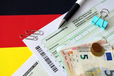 Kalem ve avrupa banknotlarıyla birlikte Almanya 'nın vergi iade formu bayrağa yakın duruyor. Almanya 'daki vergi mükellefleri, vergi ödemek için ana para birimi olarak avro para kullanıyorlar