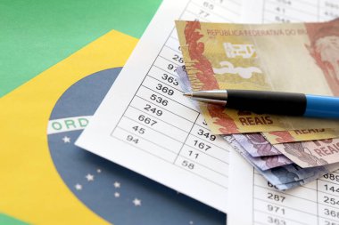 Brezilya cumhuriyetinin bayrağında Brezilya parası olan bir kalem. Brezilya 'da iş, muhasebe veya vergi ödeme kavramı