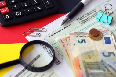 Kalem ve avrupa banknotlarıyla birlikte Almanya 'nın vergi iade formu bayrağa yakın duruyor. Almanya 'daki vergi mükellefleri, vergi ödemek için ana para birimi olarak avro para kullanıyorlar