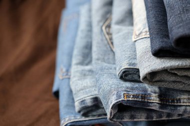 Soyunma odasında bir sürü kot pantolon var. Dolapta pantolon pantolonu var. Satın alma, satma, alışveriş ve modern kıyafetler kavramı