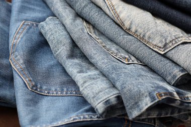 Soyunma odasında bir sürü kot pantolon var. Dolapta pantolon pantolonu var. Satın alma, satma, alışveriş ve modern kıyafetler kavramı