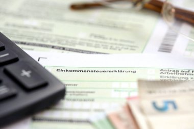 Avrupa avroluk para ve hesap makinesi ile birlikte Almanya 'nın gelir vergisi iade formu muhasebeci masasının üzerinde duruyor. Almanya ve Avrupa 'da vergi ödeme dönemi kavramı