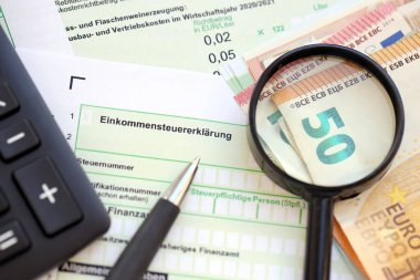 Kalem ve avrupa para faturalarıyla birlikte Alman gelir vergisi iadesi formu muhasebeci masasına yakın duruyor. Almanya 'daki vergi mükellefleri, vergi ödemek için ana para birimi olarak avro para kullanıyorlar