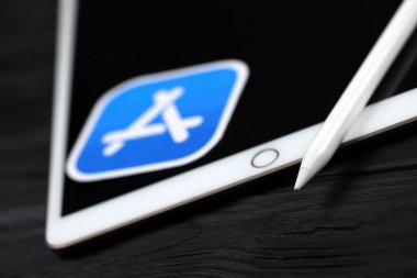 KHARKIV, UKRAINE - 27 Ocak 2021: Yepyeni Apple iPad ve Apple kalem ve siyah arkaplanda mavi uygulama mağaza logosu. Apple Inc. merkezi Kaliforniya 'da bulunan bir Amerikan teknoloji şirketidir.
