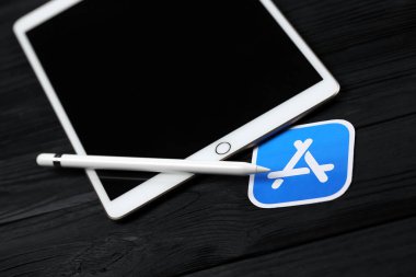 KHARKIV, UKRAINE - 27 Ocak 2021: Yepyeni Apple iPad ve Apple kalem ve siyah arkaplanda mavi uygulama mağaza logosu. Apple Inc. merkezi Kaliforniya 'da bulunan bir Amerikan teknoloji şirketidir.